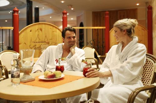 a man and a woman sitting at a table at Schlosshotel Lacknerhof in Flachau
