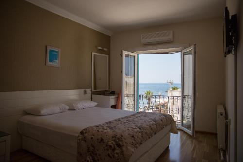 a bedroom with a bed and a view of the ocean at Kortan Hotel in Turgutreis