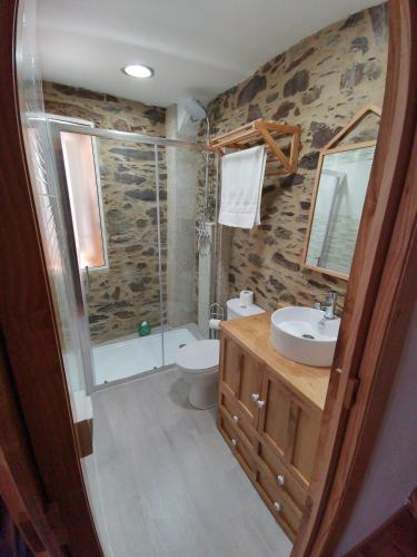 a bathroom with a shower toilet and a sink at Casa Lolola in Sada