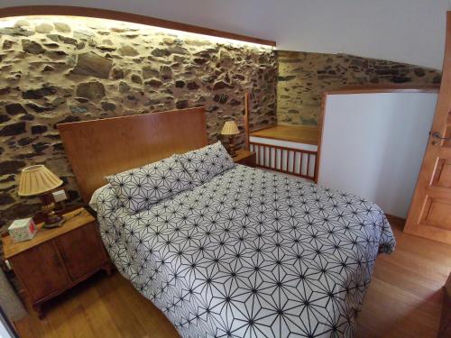 a bedroom with a bed and a stone wall at Casa Lolola in Sada