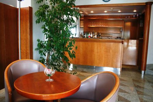 a wooden table and chairs with a wine glass on it at Hotel Villa Marija in Tučepi
