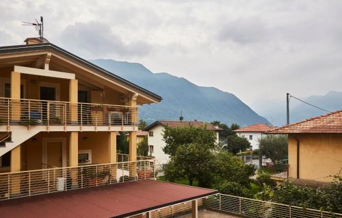un edificio con balcone con una montagna sullo sfondo di Apartment Alessandra a Lenno