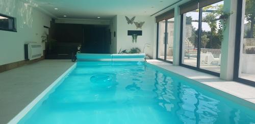 a swimming pool with blue water in a house at Villa Amor in Touguinho