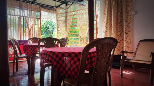 d'une salle à manger avec une table, des chaises et une fenêtre. dans l'établissement DERO BEACH HOLIDAY HOME, à Batticaloa