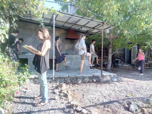 a woman holding a frisbee in front of a group of people at Karine B&B in Yeghegnadzor