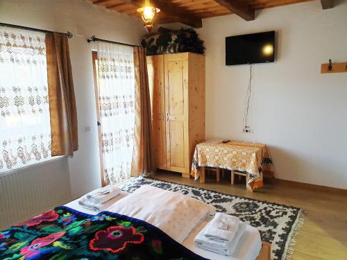 a room with a bed and a television and a table at Popas in Breb in Breb