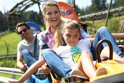 a woman and a girl riding on a roller coaster at Schlosshotel Lacknerhof in Flachau