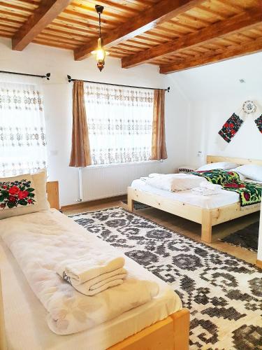 a bedroom with two beds and a rug at Popas in Breb in Breb