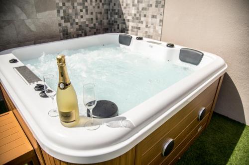 a bath tub with a bottle of champagne and wine glasses at Villa situada en Maspalomas Gran Canaria, in Maspalomas