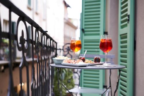 a table with food and wine glasses on a balcony at Locanda delle Mercanzie in Brescia