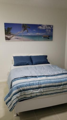 a bedroom with a bed with four paintings on the wall at Aldeia dos reis - Condado - Mangaratiba - Loft 405 bl 3 in Mangaratiba