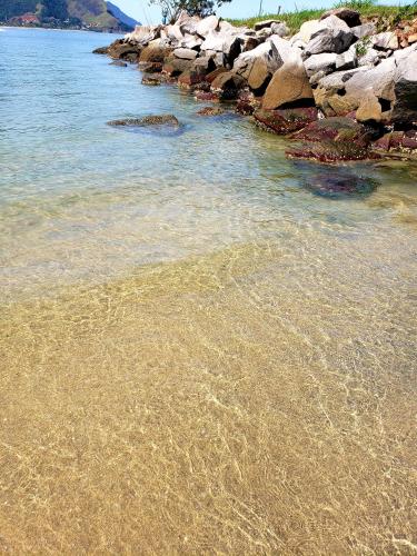a beach with rocks and the water at Aldeia dos reis - Condado - Mangaratiba - Loft 405 bl 3 in Mangaratiba