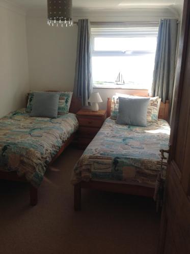 two beds in a room with a window at Tyisha in Cardigan