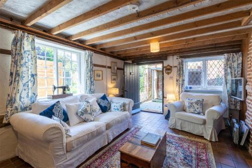 a living room with two couches and a tv at Primrose Cottage at The Shippe in Bridge