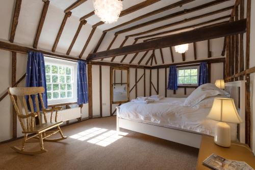 a bedroom with a bed and a chair in a room at Primrose Cottage at The Shippe in Bridge