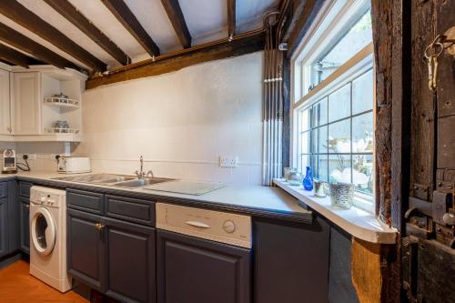 a kitchen with a sink and a window at Primrose Cottage at The Shippe in Bridge