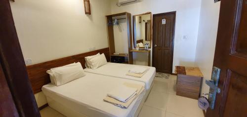 a small room with a bed and a mirror at Surf Deck in Thulusdhoo