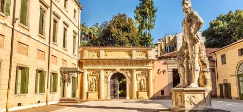 uma estátua de uma mulher em frente a um edifício em Palazzo Mantua Benavides Suites & Apartments em Pádua