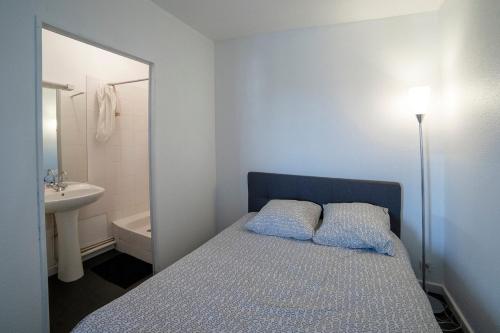 a bedroom with a bed and a bathroom with a sink at PROCHE BORDEAUX APPARTEMENT 75 M2 ROOFTOP in Bruges