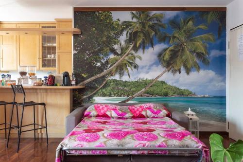 a kitchen with a bedroom with a palm tree mural at Appartamento Fornace in Padova
