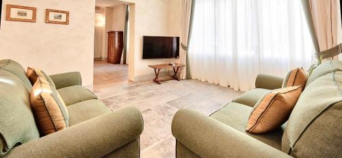 a living room with couches and a flat screen tv at Palazzo Mantua Benavides Suites & Apartments in Padova