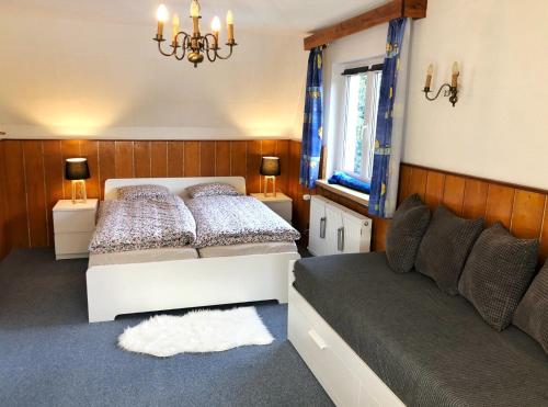 a bedroom with two beds and a couch and a chandelier at Horský dům Pernink in Pernink