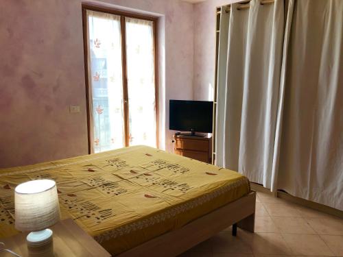 a bedroom with a bed and a television and a window at SweetHome Fabio&Stefy in Guidonia