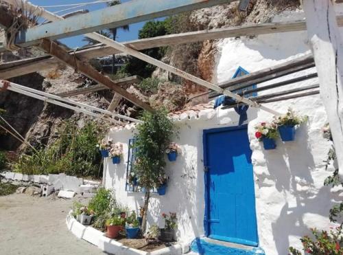 niebieskie drzwi na białym budynku z doniczkami w obiekcie Playa Burriana Rubasol Nerja w mieście Nerja