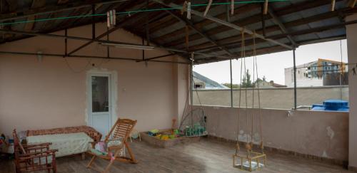 una camera con sedie e un letto sul balcone di Pospolita Guest House a Kutaisi