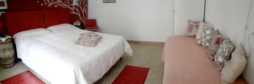 a bedroom with a white bed with a red headboard at Le Terrazze Sul Pollino B&B in Civita