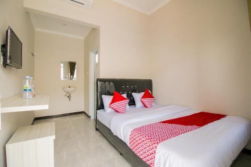 una camera da letto con un letto con cuscini rossi e bianchi di Super OYO 1078 Fakhira Residence a Cianjur