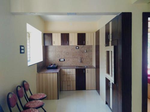 una cocina con armarios de madera y fregadero en Krishna Kausthubha en Udupi