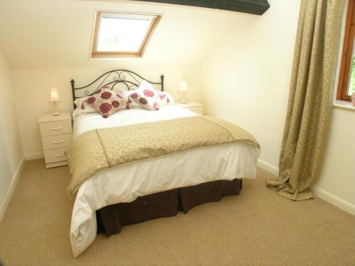1 dormitorio con cama con almohadas y ventana en Falstaff Cottage for up to 5, Stratford upon Avon, en Stratford-upon-Avon