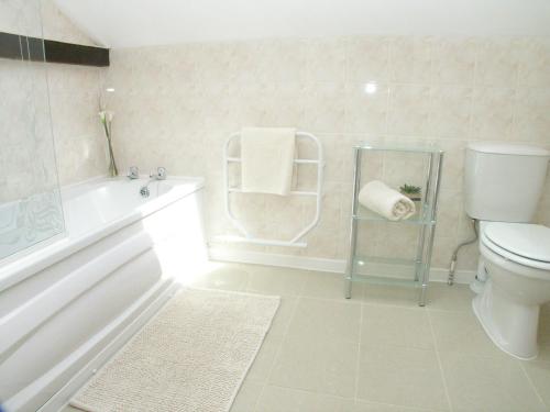 a bathroom with a toilet and a tub and a sink at Falstaff Cottage for up to 5, Stratford upon Avon in Stratford-upon-Avon