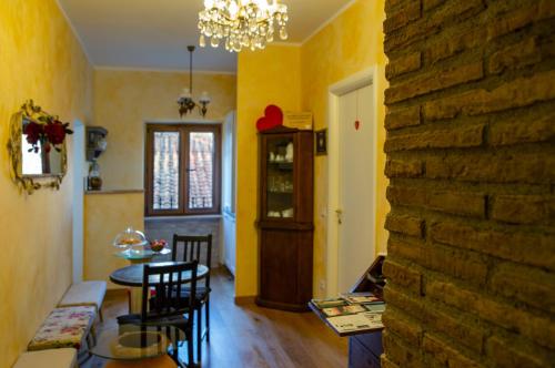 a living room with a table and chairs and a brick wall at B&B Buonfiglio Cicconcelli - Terrazza panoramica in Frascati