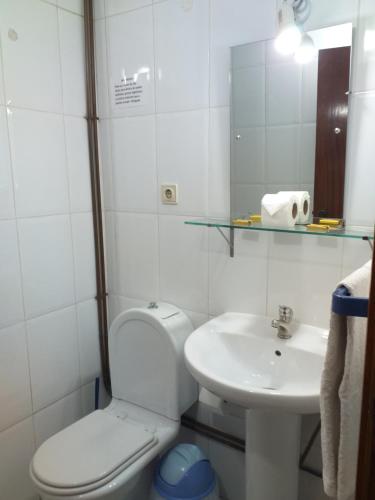 a white toilet sitting next to a sink in a bathroom at Residencial Encontro in Vila Real