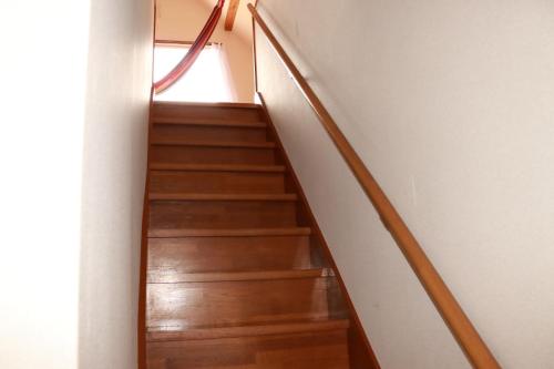 a staircase in a house with wooden floors at 陽のあたる宿 サンセットパーム in Oshima