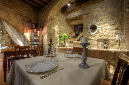 una sala da pranzo con tavolo e candela di Residenza d'epoca Torre dei Serviti a Casole dʼElsa