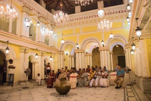 a group of people standing in a large building at COSSIMBAZAR PALACE OF THE ROYS ( RAJBARI) in Cossimbāzār