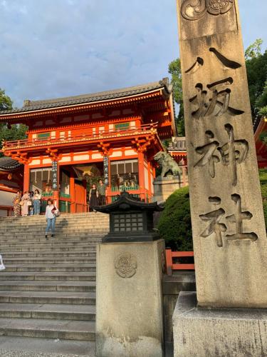 un edificio arancione con una statua davanti di 明和荘Mei Wa Inn a Kyoto