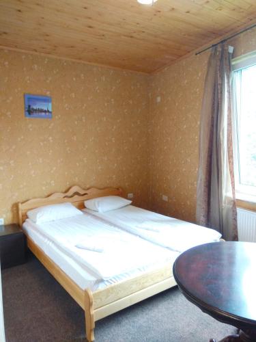 a small bedroom with a bed and a table at Guest House Pid Dubom in Lviv
