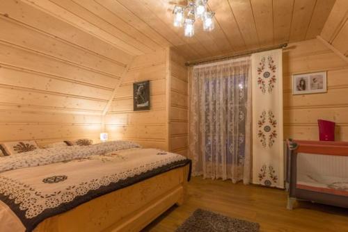 スヘにあるLuksusowe Domki Elizy Luxury Chalets Poroninの丸太小屋のベッドのある寝室