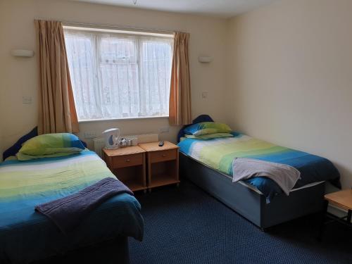 - une chambre avec 2 lits, une fenêtre et une table dans l'établissement Tower House Hotel, à Reading