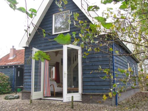 a blue tiny house with a white door at Vakantiewoning "De Kei" in Warns