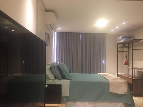 Charmoso e Confortável في برازيليا: غرفة نوم بسرير اخضر ونافذة