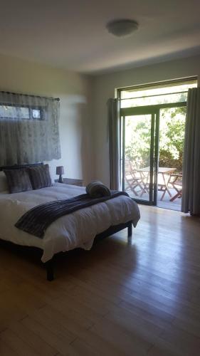 a bedroom with a bed and a sliding glass door at 91 Da Gama Beach House in Cape St Francis