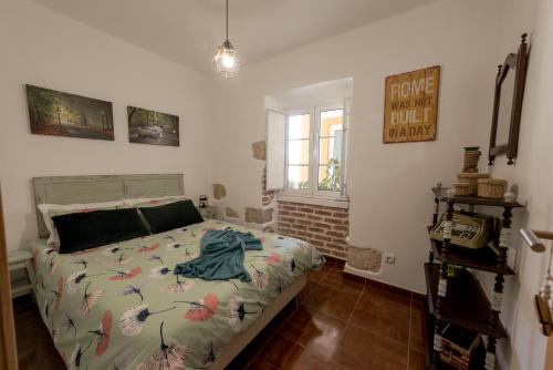 Un dormitorio con una cama con un edredón con pájaros. en Casa do Lagar, en Óbidos