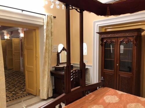 a room with a bed and a mirror and a door at COSSIMBAZAR PALACE OF THE ROYS ( RAJBARI) in Cossimbāzār