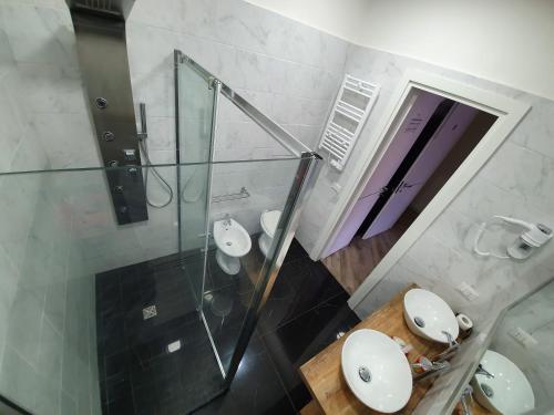 ein Badezimmer mit zwei Waschbecken und einer Glasdusche in der Unterkunft Dimorra Boutique Rooms in Neapel