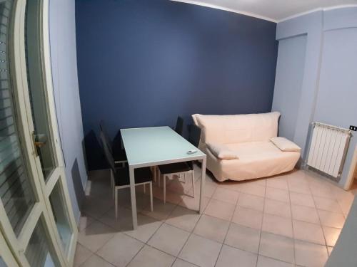 Cette petite chambre comprend une table blanche et une chaise. dans l'établissement A due passi dal mare, à Marina di Carrara